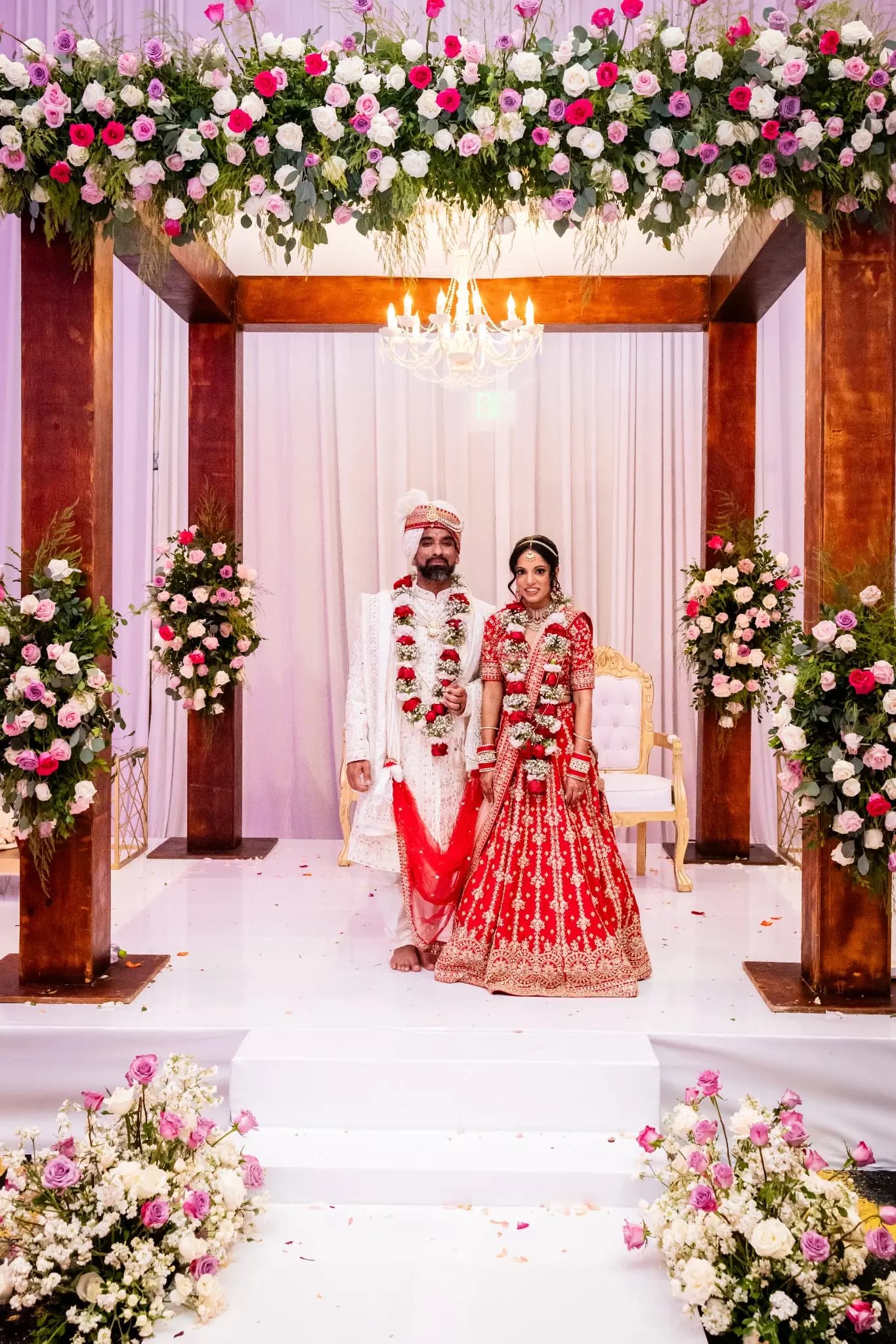 Couple beneath a floral mandap at a family wedding in Mexico